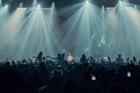 Escenario de Black Coffee, con él tocando musica y con las siluetas del público bailando