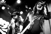 Foto de un cantante en primer plano y detrás el guitarrista en Rock en Familia