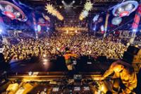 Mesa de DJ en New Year's Padana Project encima del escenario y mucha gente bailando de fondo