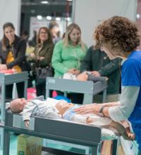 Mujer pintando un dibujo en la tripa de una embarazada.