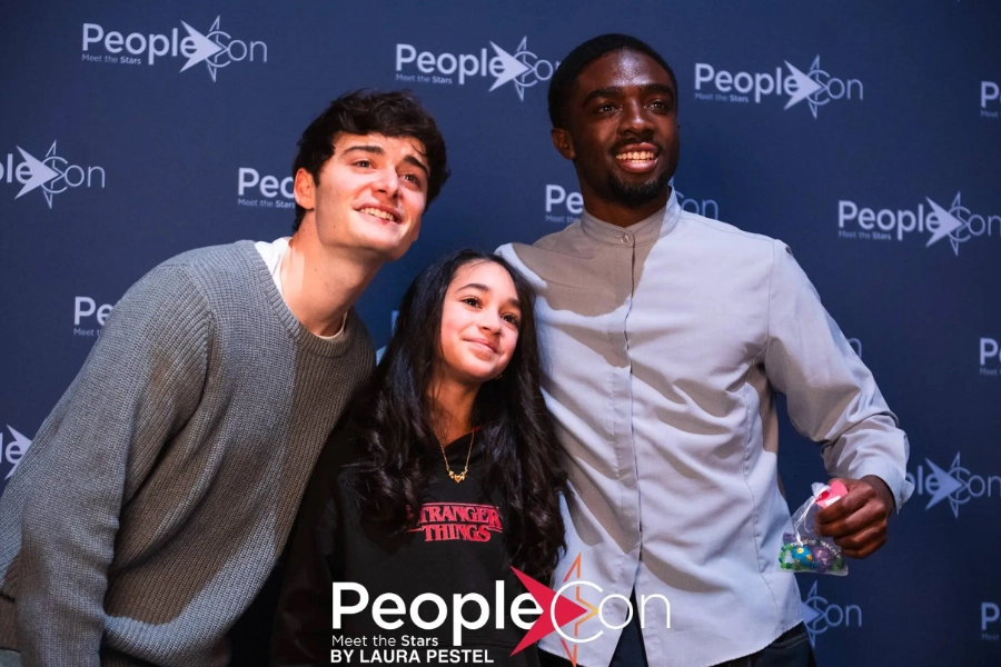 Noah and Caleb at the Stranger Things event posing with a fan