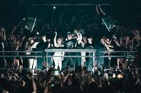 Outworld encima del escenario rodeado de gente levantando el brazo