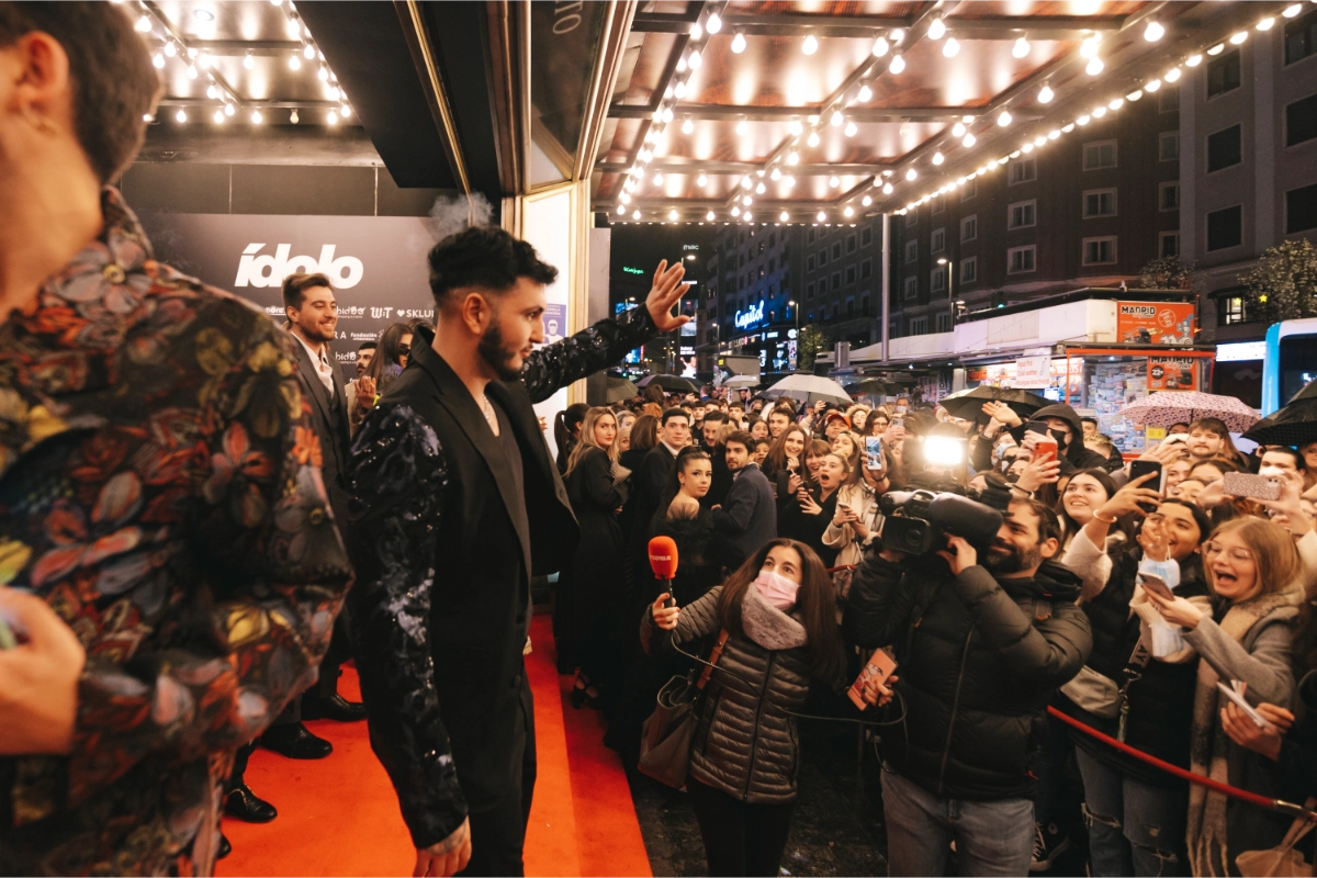 persona saludando a la prensa en la entrada de los premios idolo