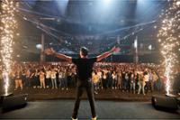 ponente abriendo los brazos delante del publico en Reinicia tu negocio