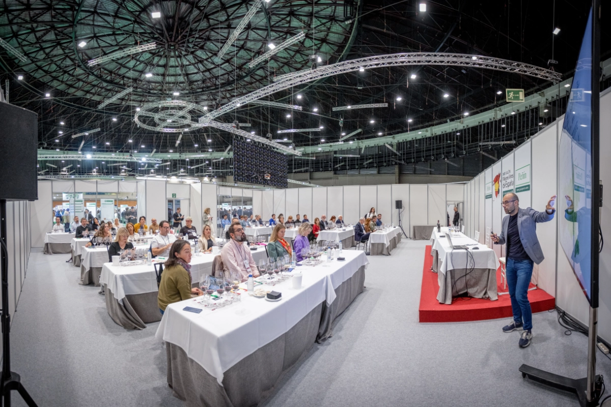 Ponente en salon Peñin exponiendo delante de personas que están con mesas