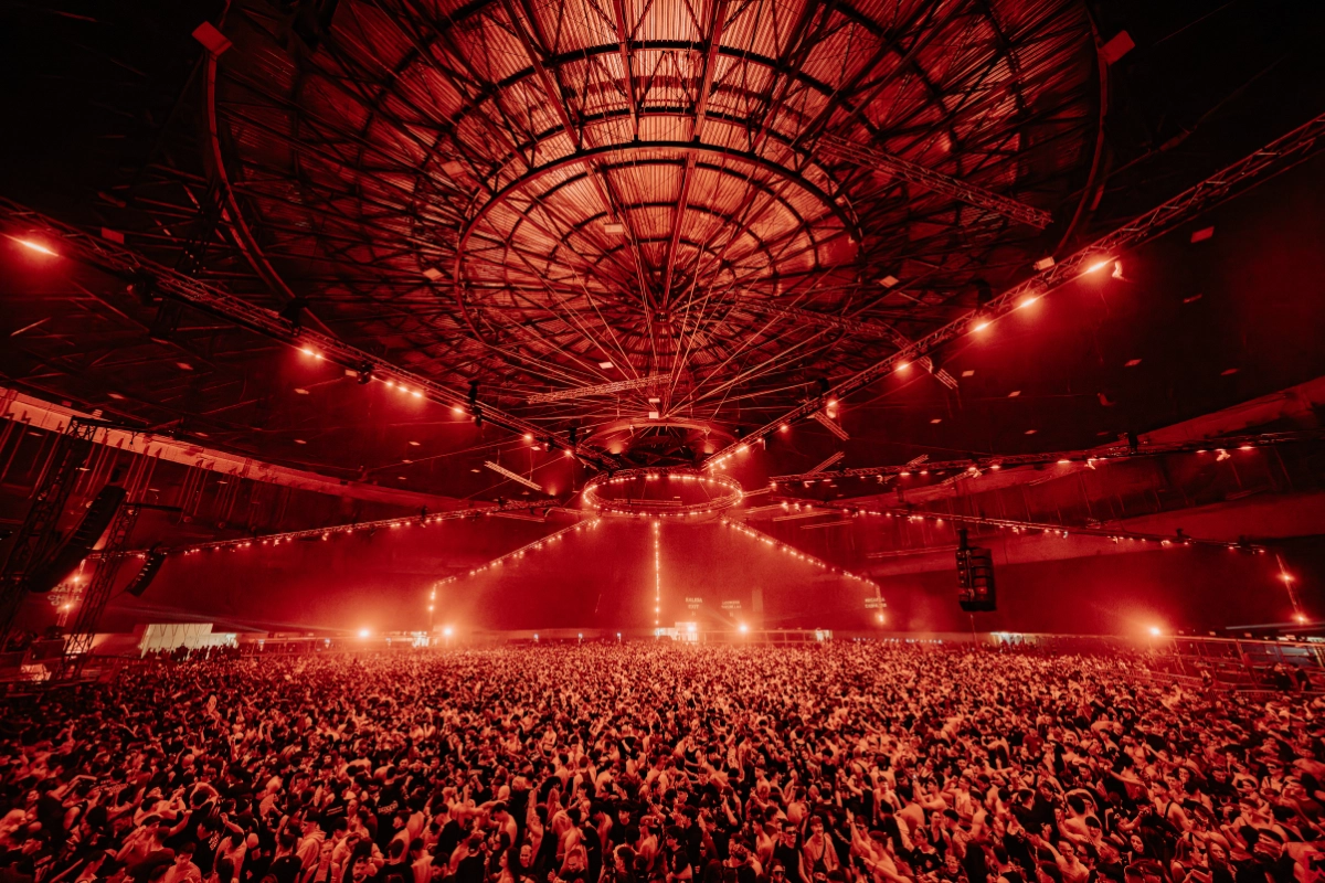 Público de blackworks-festival bailando con luces rojas encima de ellos con el nombre del evento