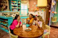 Tres chicas sentadas en la mesa de la cocina de The FRIENDS Experience