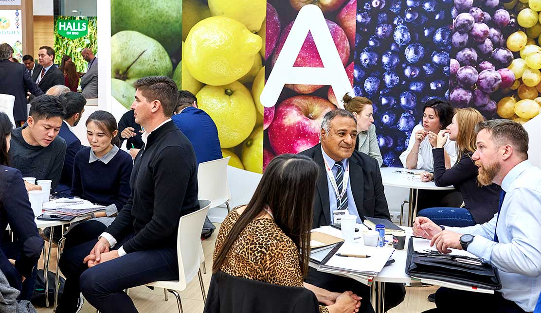 Visitantes y expositores conversando durante la feria