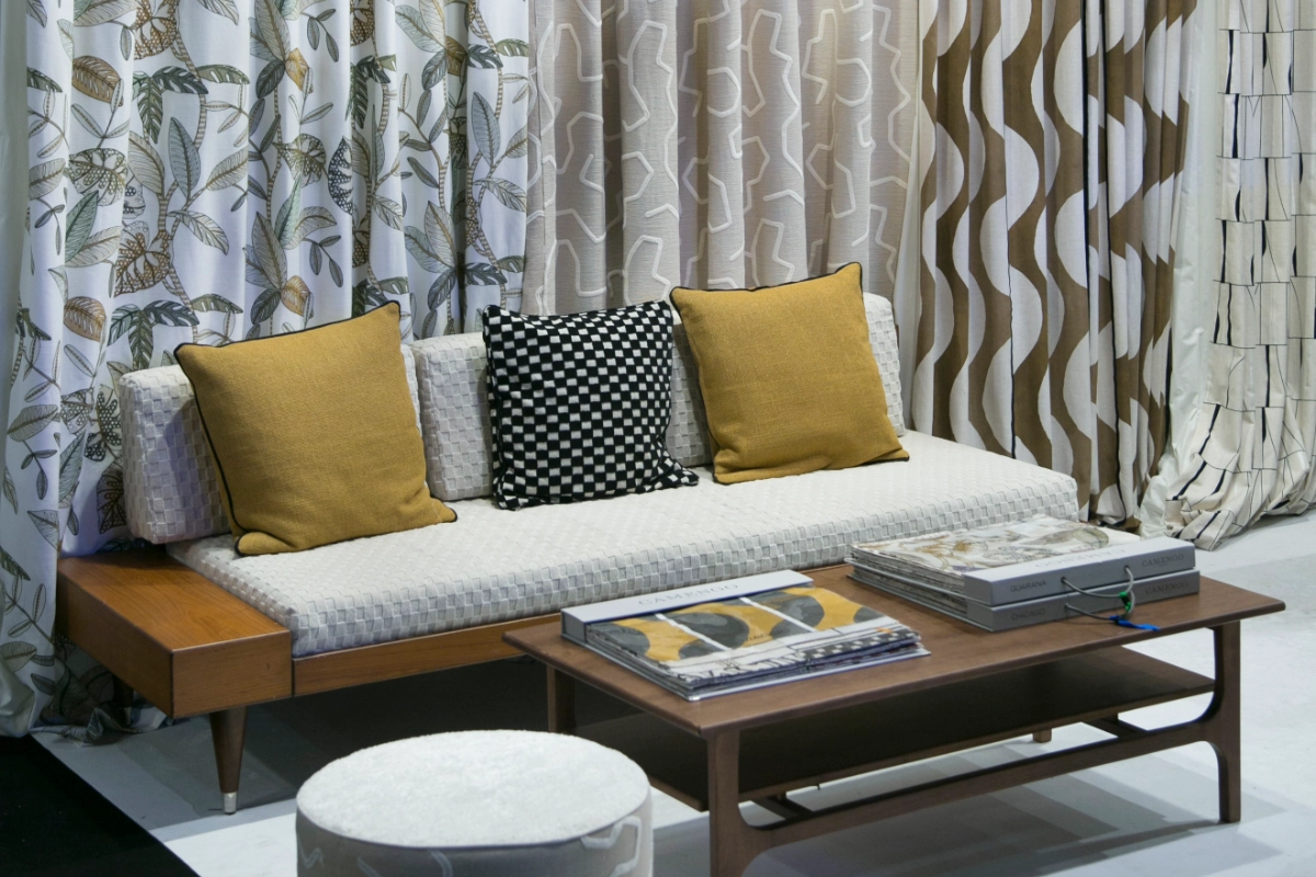 White sofa with yellow and grey cushions, featuring fabrics by Editores Textiles from Intergift