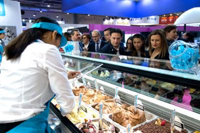 expositor de heladeria con visitantes observando.