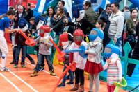Niños y niñas jugando a esgrima con espadas de espuma.