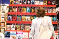 Mujer observando una estantería llena de libros.
