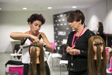 Two hairdressers with mannequins doing demonstrations