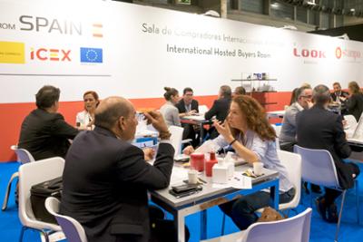 sala con mesas y personas reunidas.