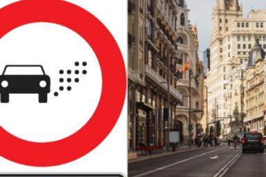 Una calle céntrica y señal de baja emisiones para vehículos