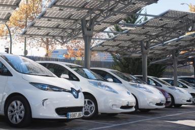 Una hilera de vehículos eléctricos en un parking con placas solares