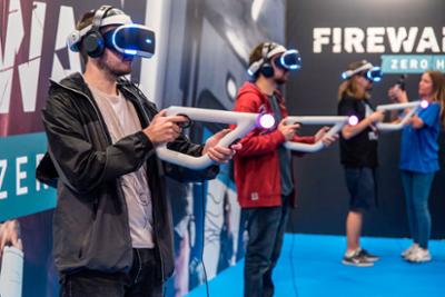 Personas probando gafas y pistola de realidad virtual.