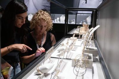 Women looking at gold earrings.