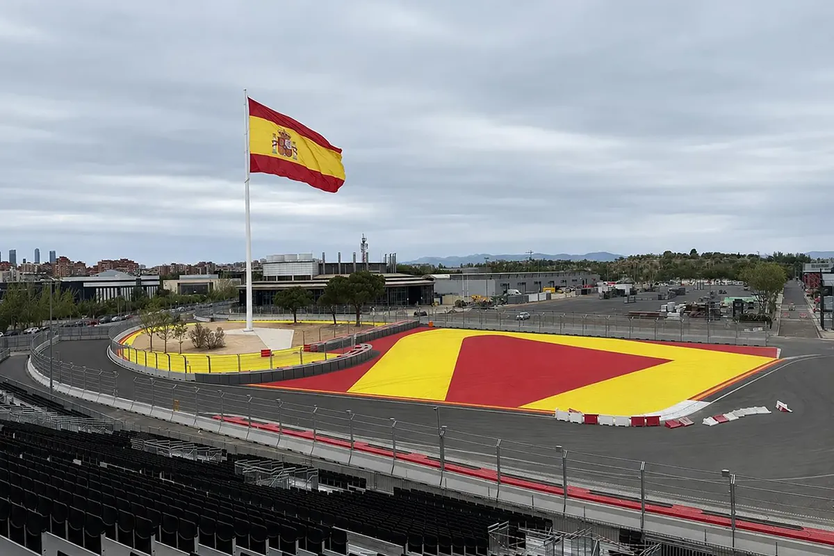 Aerial view of a corner at the Madring Formula 1 circuit in Madrid with the main grandstand and Spanish flag.