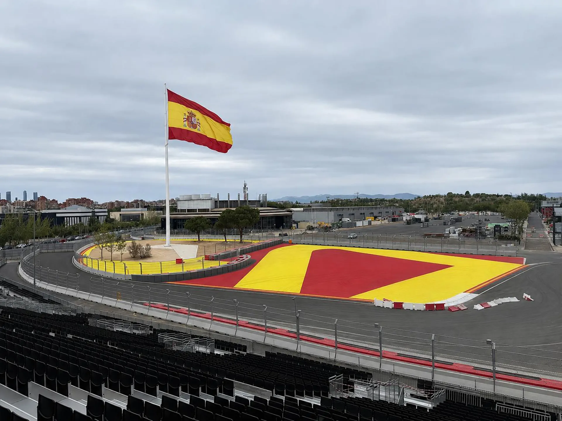 Aerial view of a corner at the Madring Formula 1 circuit in Madrid with the main grandstand and Spanish flag.