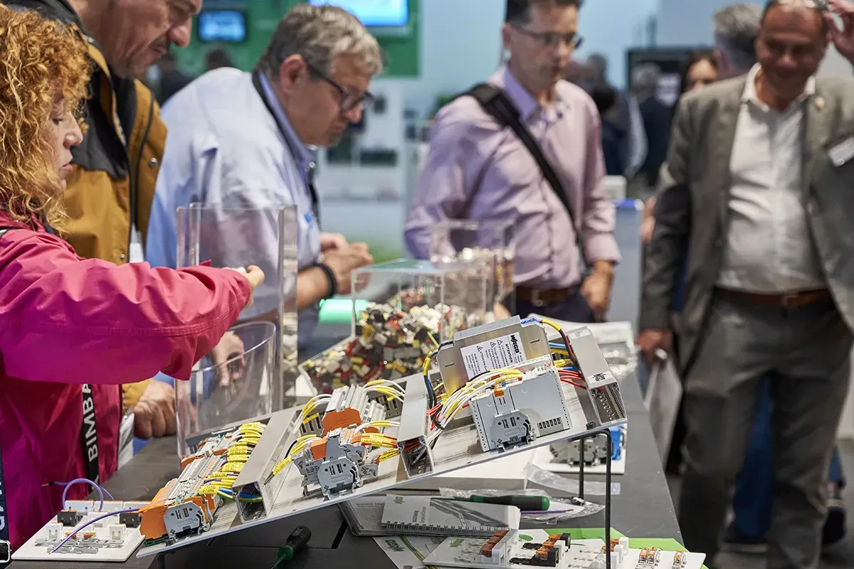 People at a stand looking at circuits