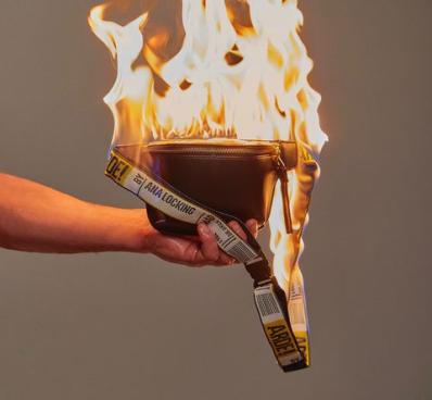 bolso ardiendo sujetado por una mano