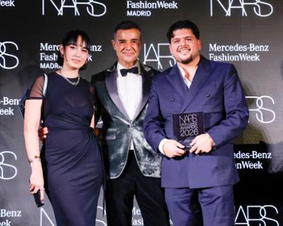 Persona galardonada posa junto a dos acompañantes en el photocall de Mercedes-Benz Fashion Week Madrid.