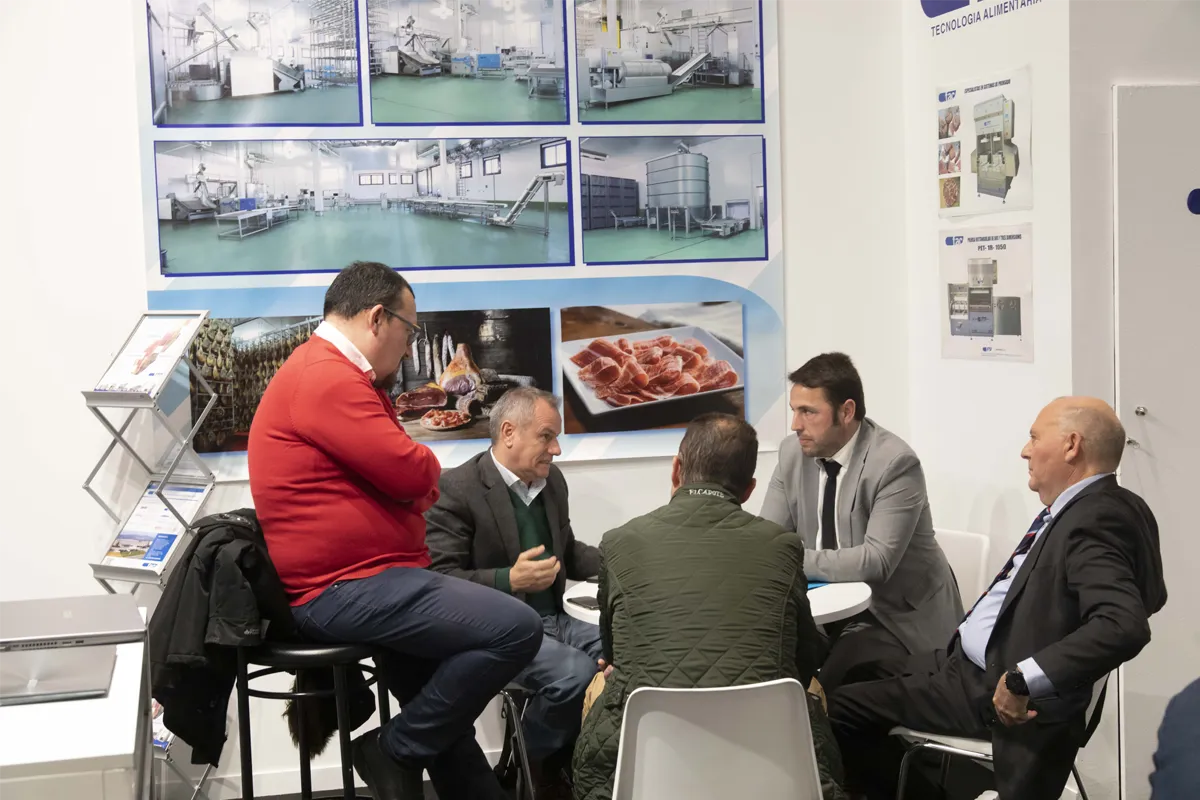 cinco hombres en una mesa redonda hablando