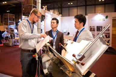 Profesionales observando una máquina de corte de carne