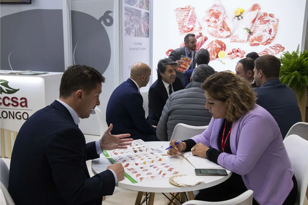 Dos personas en una mesa viendo un catalogo con distintas variedades de carnes