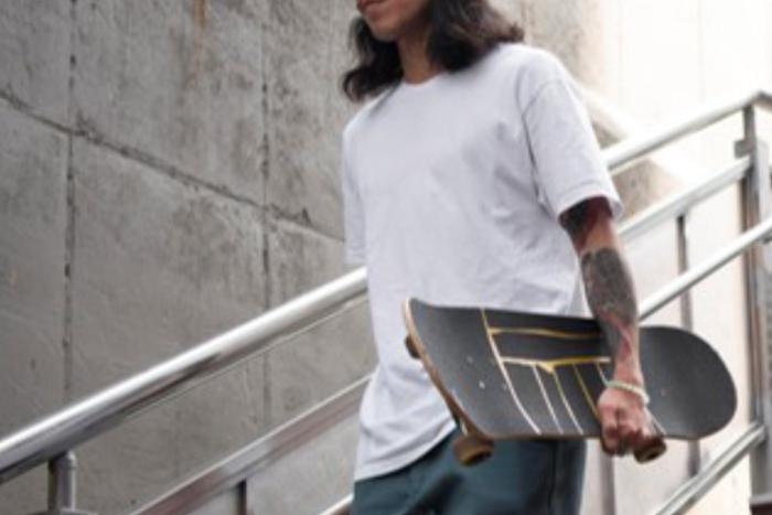 chico con camiseta blanca y monopatín