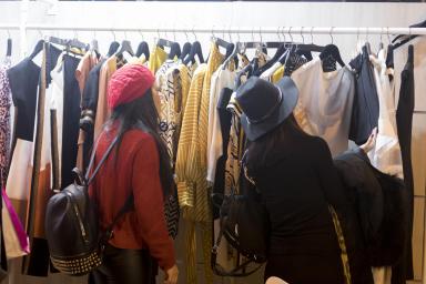 visitante viendo ropa en un stand
