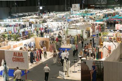 Vista general de un pasillo del pabellón con visitantes y stands.
