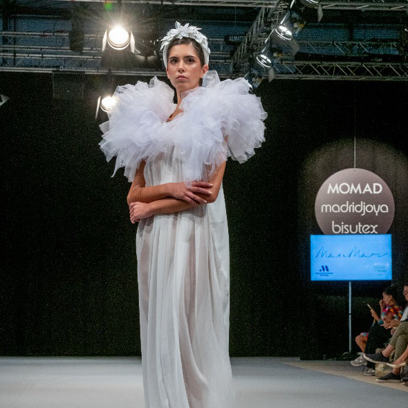 Woman on parade in a white dress at MOMAD