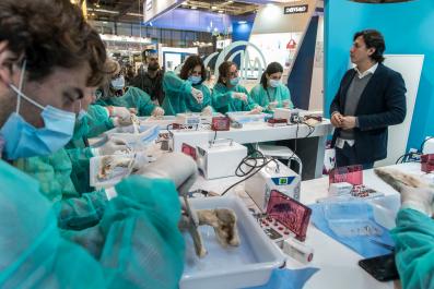 un grupo de profesionales con mascarilla trabajan con novedosos productos dentales en un stand de EXPODENTAL