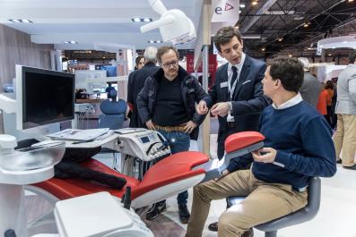 Unos profesionales en un stand comprobando el funcionamiento de un novedoso sillón para pacientes de odontología