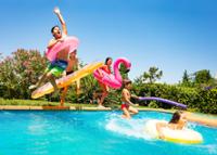 Grupo de niños y niñas saltando a una piscina.