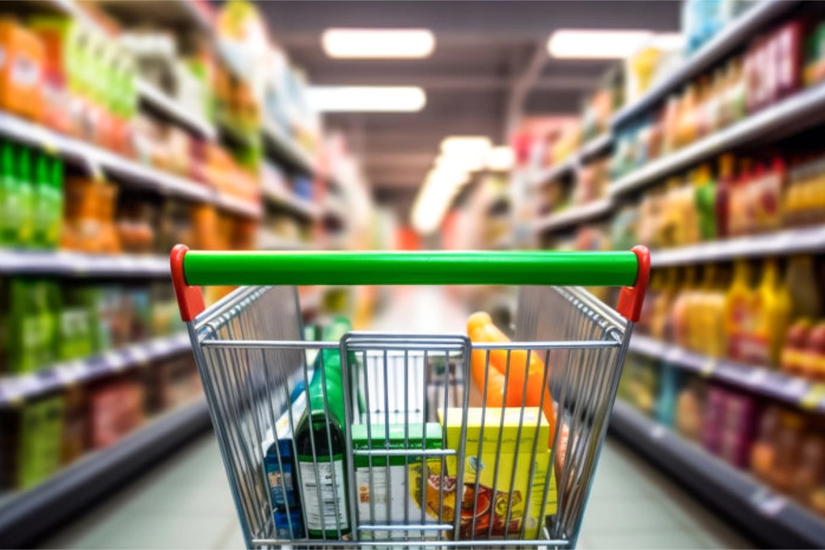 carro de la compra lleno de comida en los pasillos de un supermercado