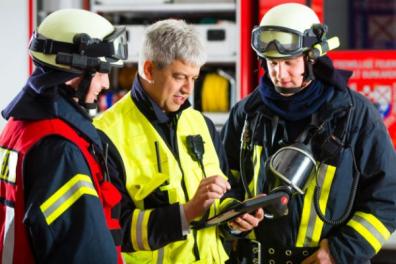 Bomberos y equipo de seguridad planificando las emergencias de una empresa.