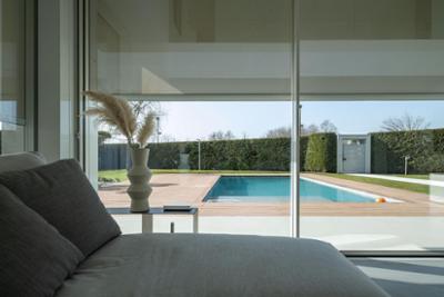 A room with glass doors overlooking a swimming pool with integrated Nice solutions.
