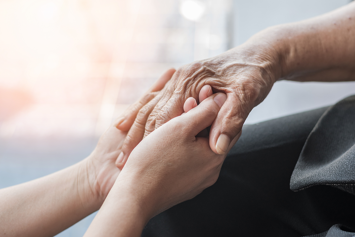 Manos de persona mayor y persona joven en SOCIOCARE
