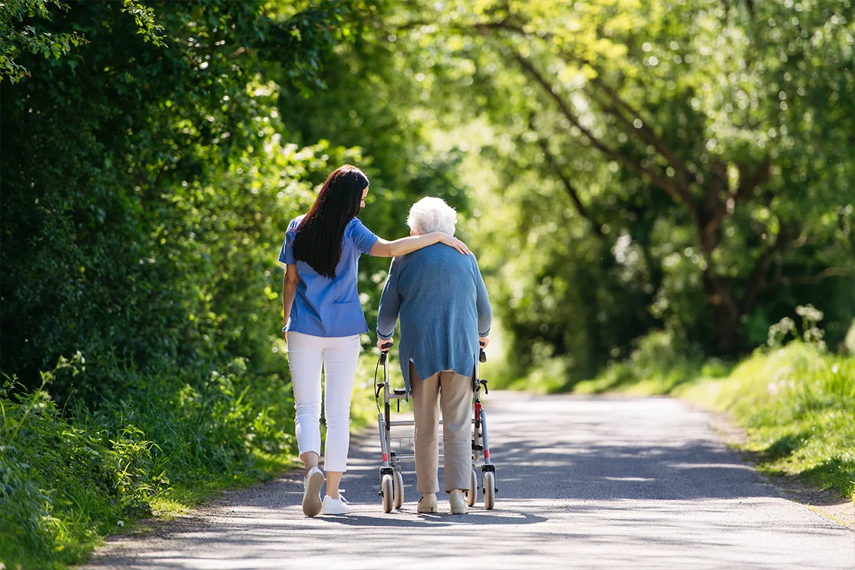 Young and elderly woman walking along a country road in Sociocare