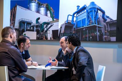 Exhibitors and visitors gathered at a table.