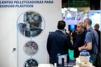 visitantes hablando con expositor de un stand.