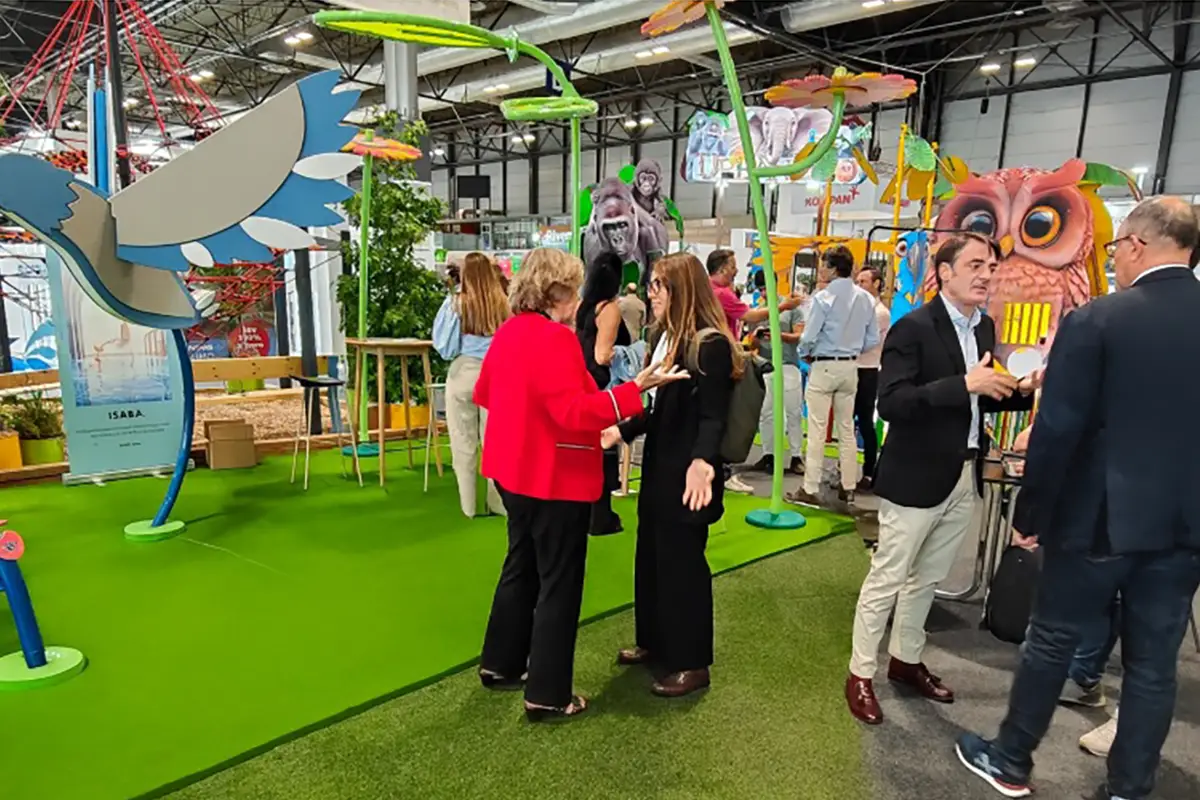 Personas conversando en un stand colorido durante la feria de TECMA