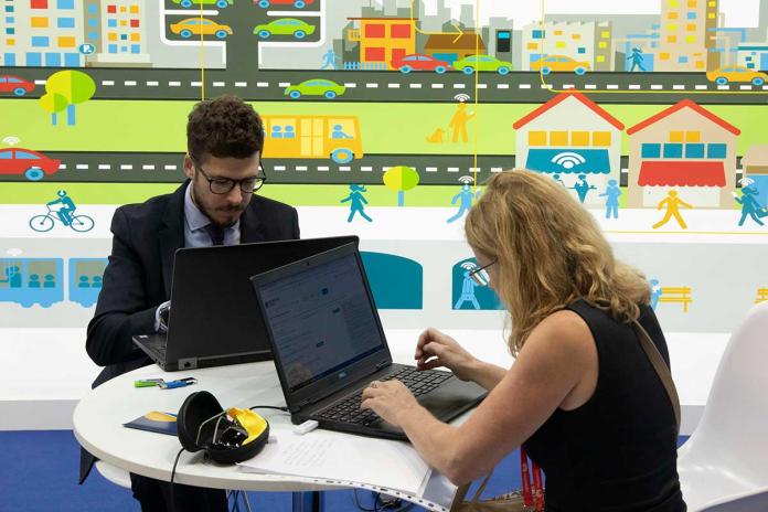 Expositores consultando su portátil