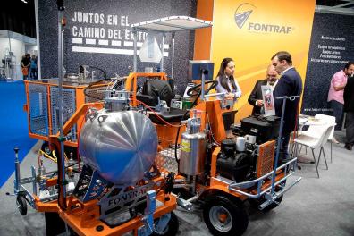 Visitantes observando una máquina de asfalto