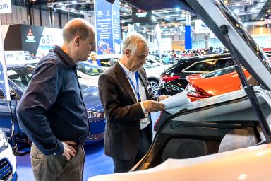 profesional y visitante leyendo los papeles del coche