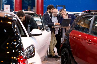 visitantes de la feria preguntando por las características de un coche