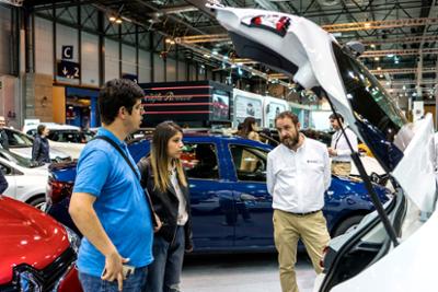 Visitantes observando un maletero de un coche.